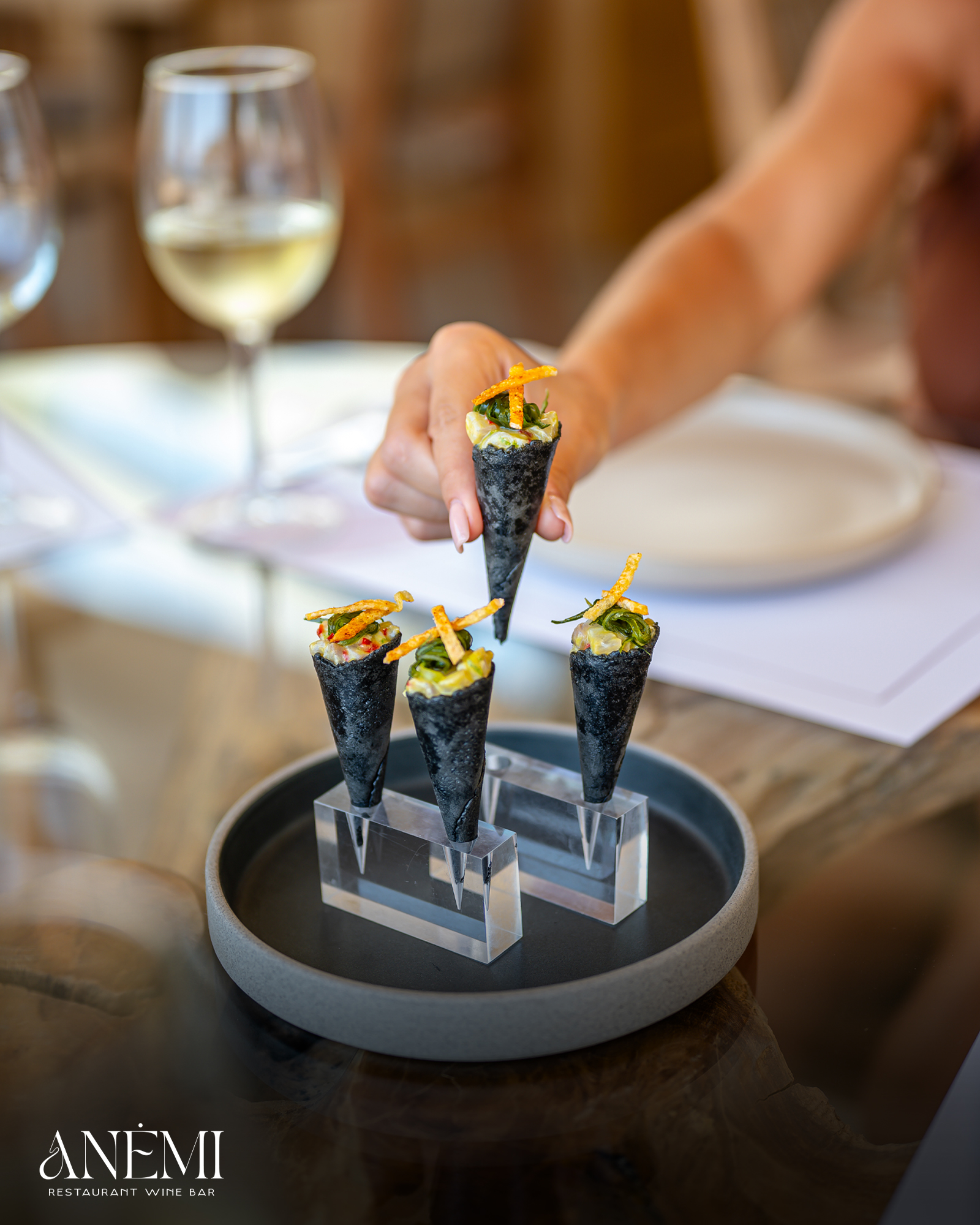 Hands plating small bites at the table